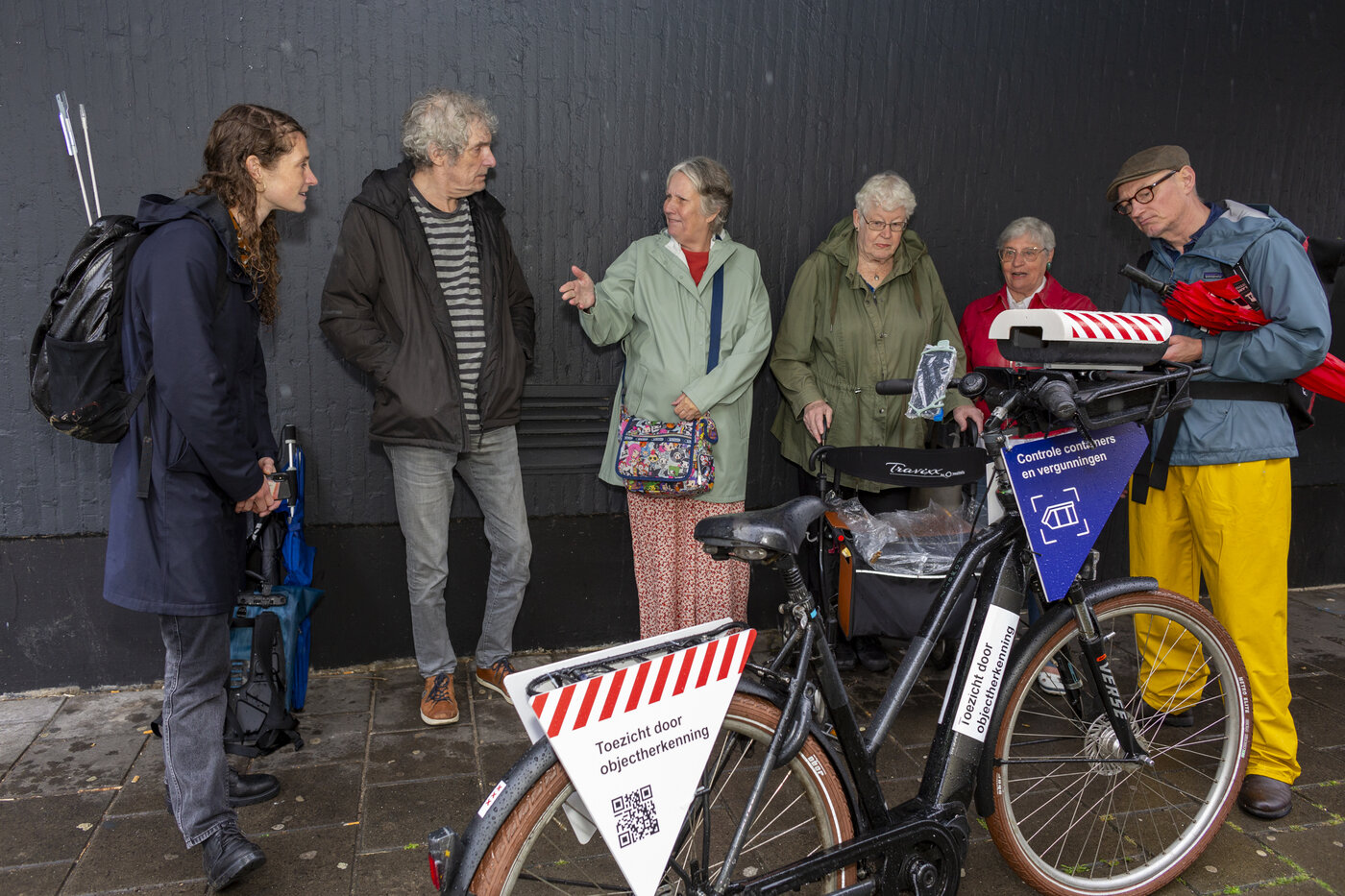 Mensen rond een scanfiets in de publieke ruimte
